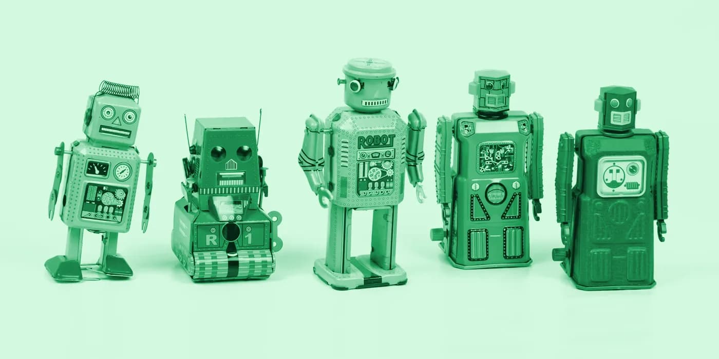 Cinco robots de juguete antiguos en fila, con un tinte verde