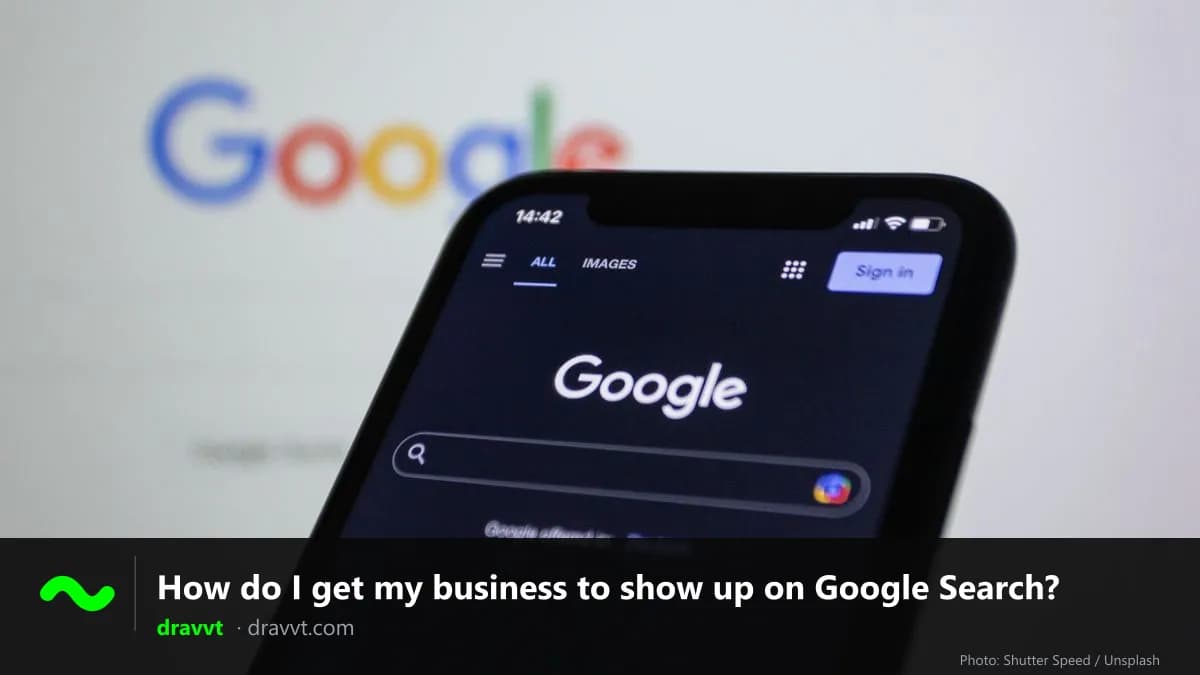 A phone showing the Google search page in front of a large Google logo, with the title “How do I get my business to show up on Google Search?” and the dravvt logo
