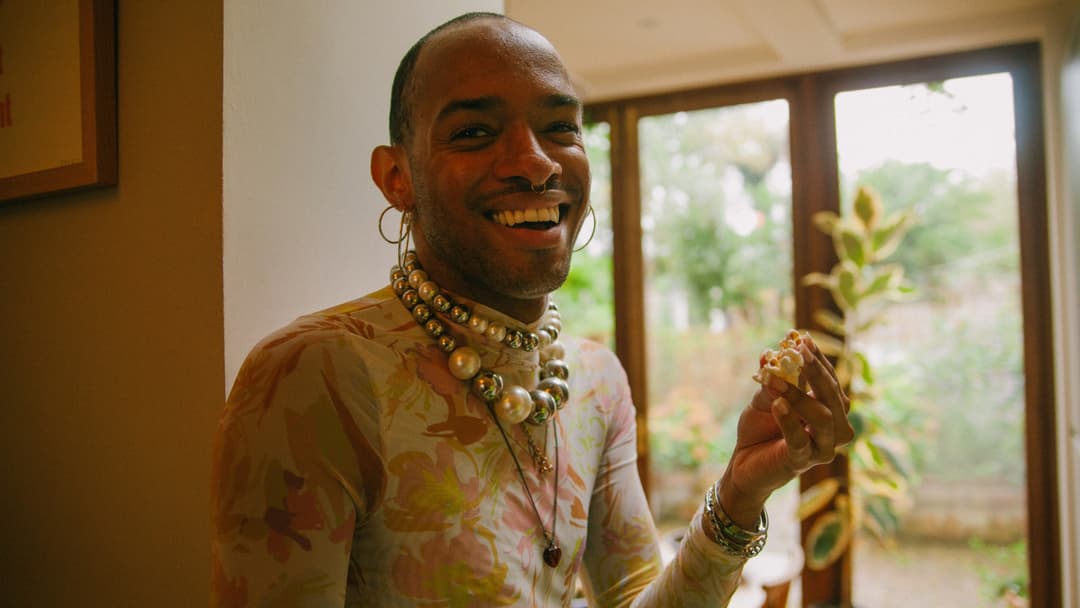 A queer artist smiling, representing the diverse identities within the art world, exploring the percentage of queer artists.