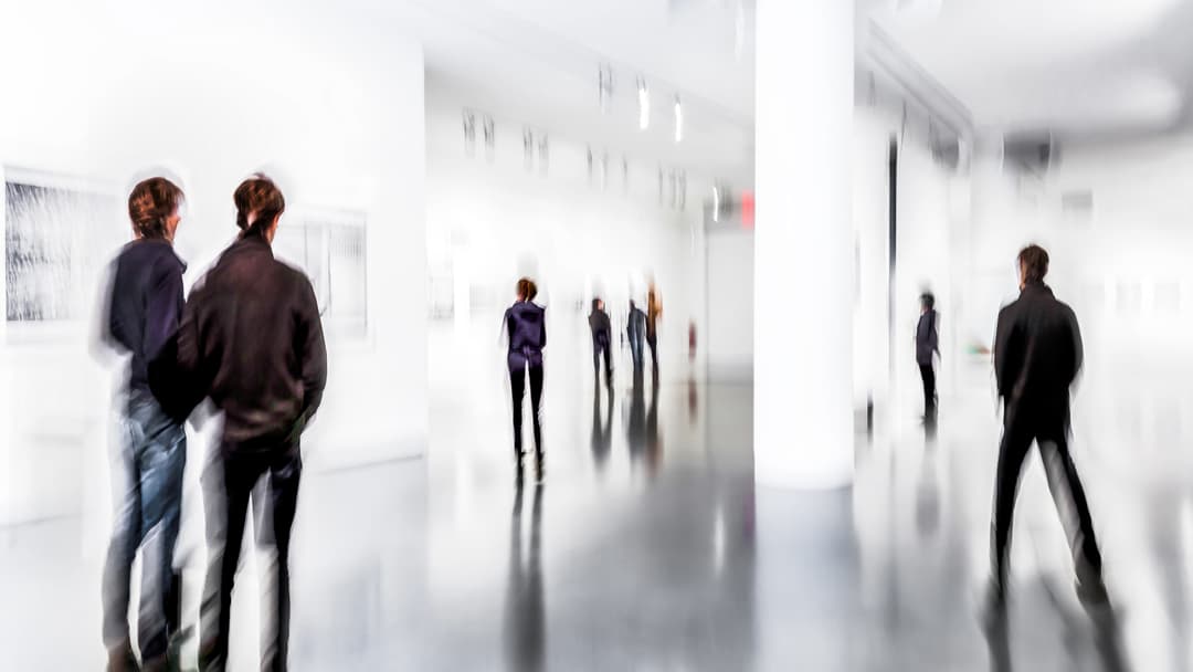 People exploring an exhibition about the Queer Art Movement, showcasing LGBTQ+ themes and artistic expressions