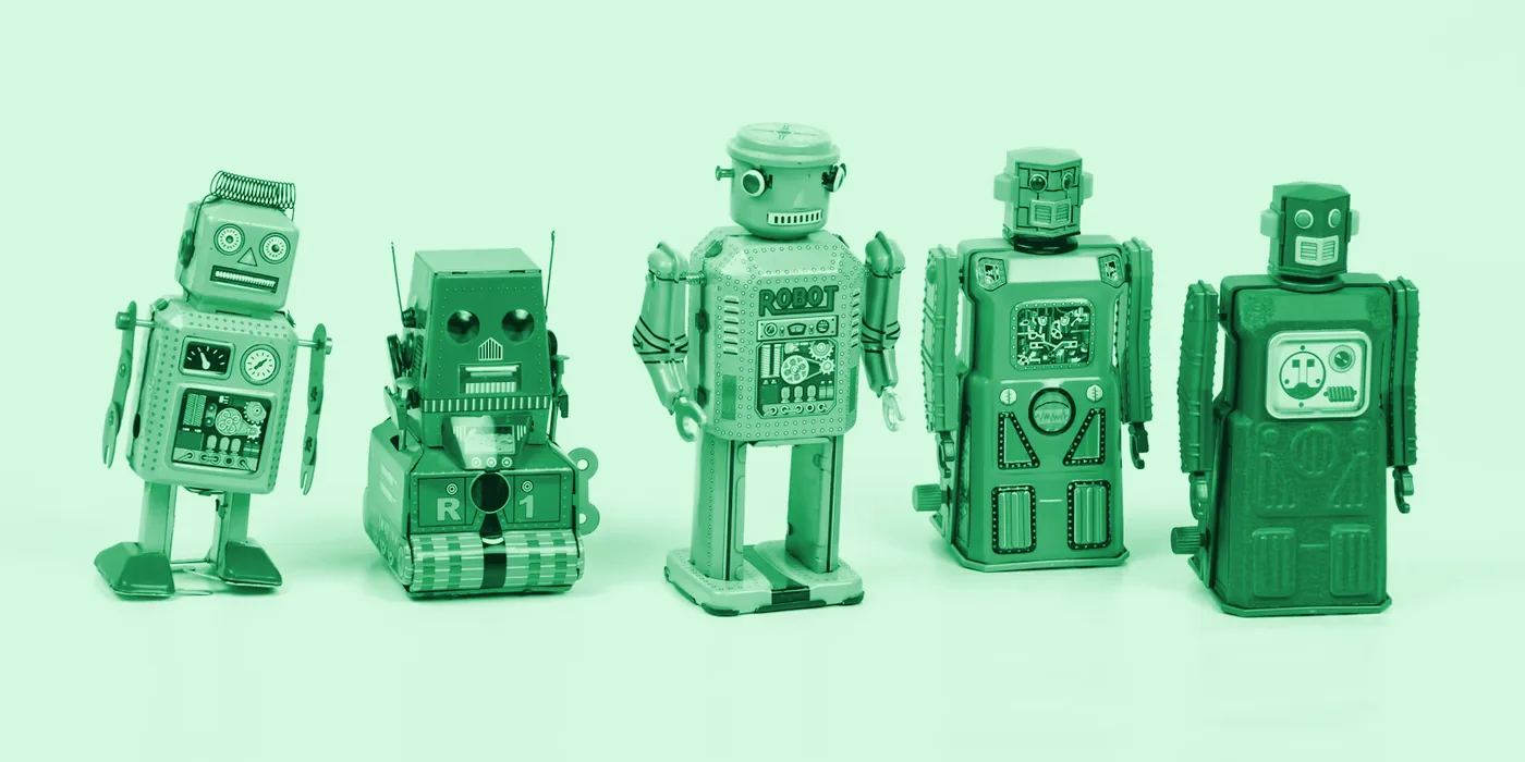 Five vintage toy robots standing in a row, with a green tint